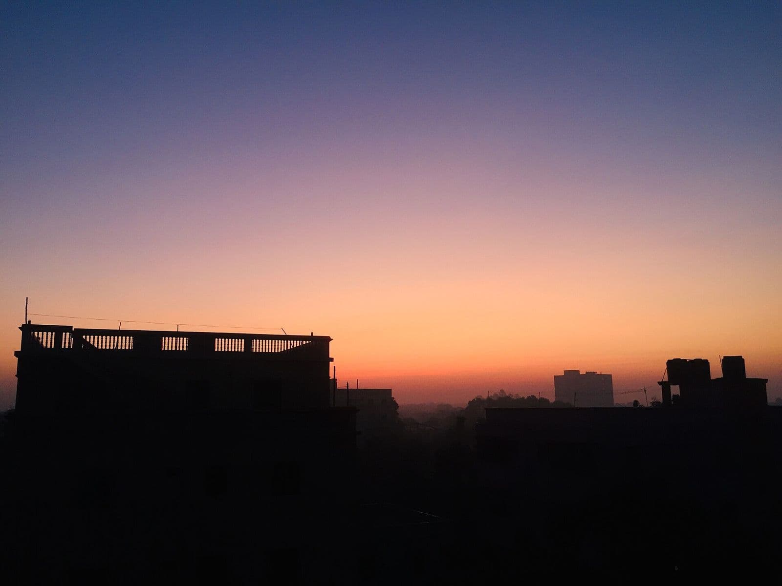 ভোরের রঙিন আকাশে টঙ্গীর ছাদের সারি